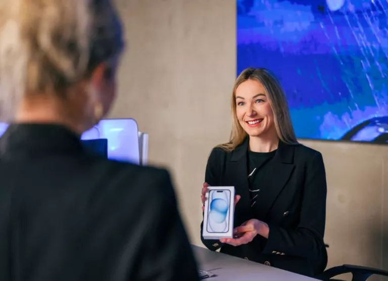 Elisa klienditeenindaja näitab iphone